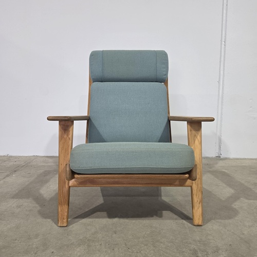Vintage GE290A lounge chair by Hans Wegner, complete with tall ergonomic backrest, head cushion, and warm oak frame, highlighting mid‑century Scandinavian design