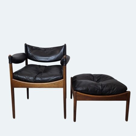 Kristian Solmer Vedel armchair and footstool in rare Brazilian rosewood with deep palisander grain, paired with black leather upholstery, photographed in natural light to highlight the sculptural Danish Modern design