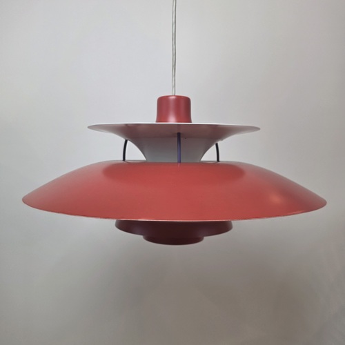 Vintage red PH 5 pendant light by Poul Henningsen suspended against a neutral background.