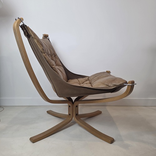 Side profile of Sigurd Ressel Falcon chair showing suspended leather seat and sculptural beech frame